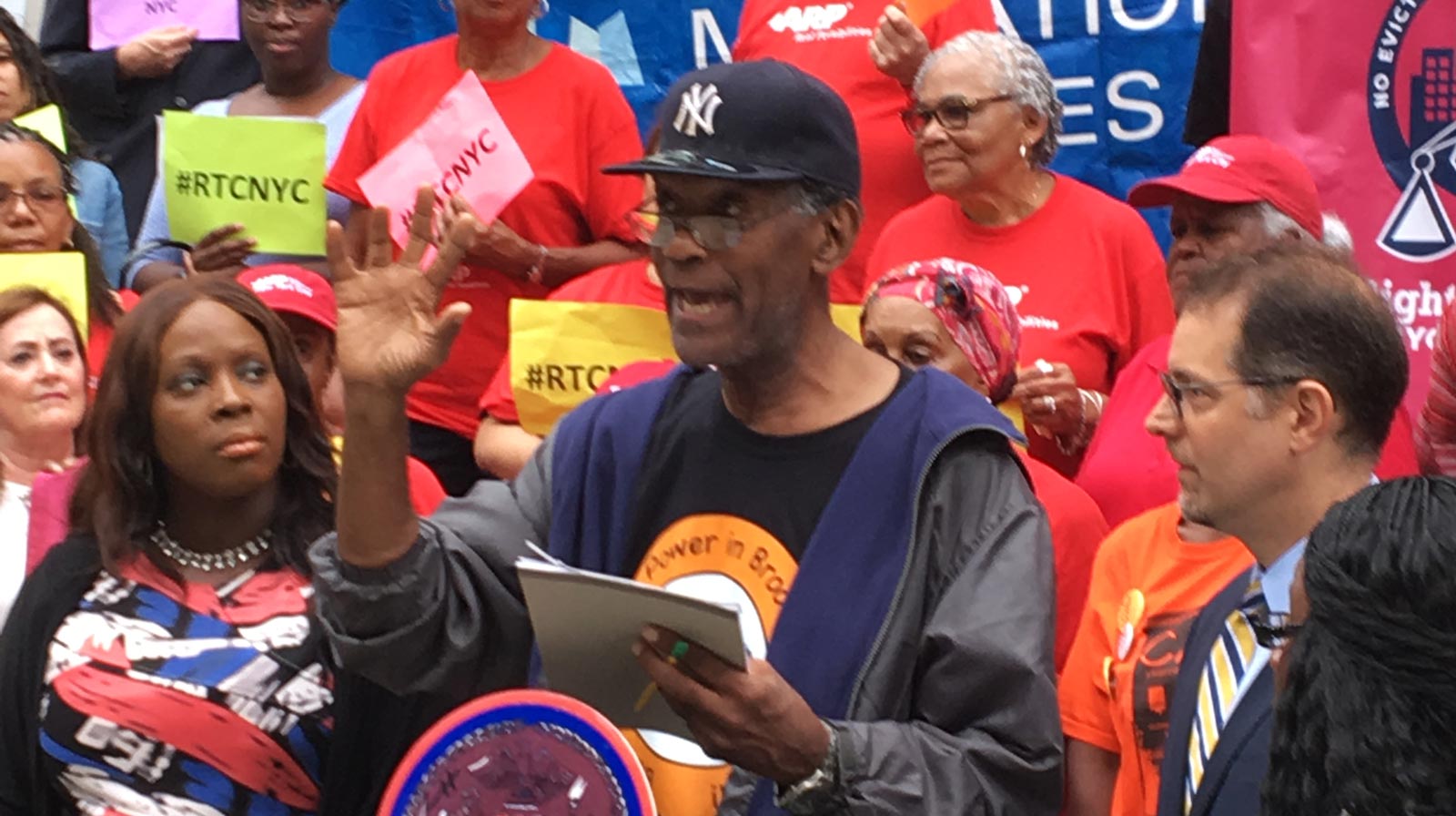 An outdoor rally featuring a tenant activist speaker